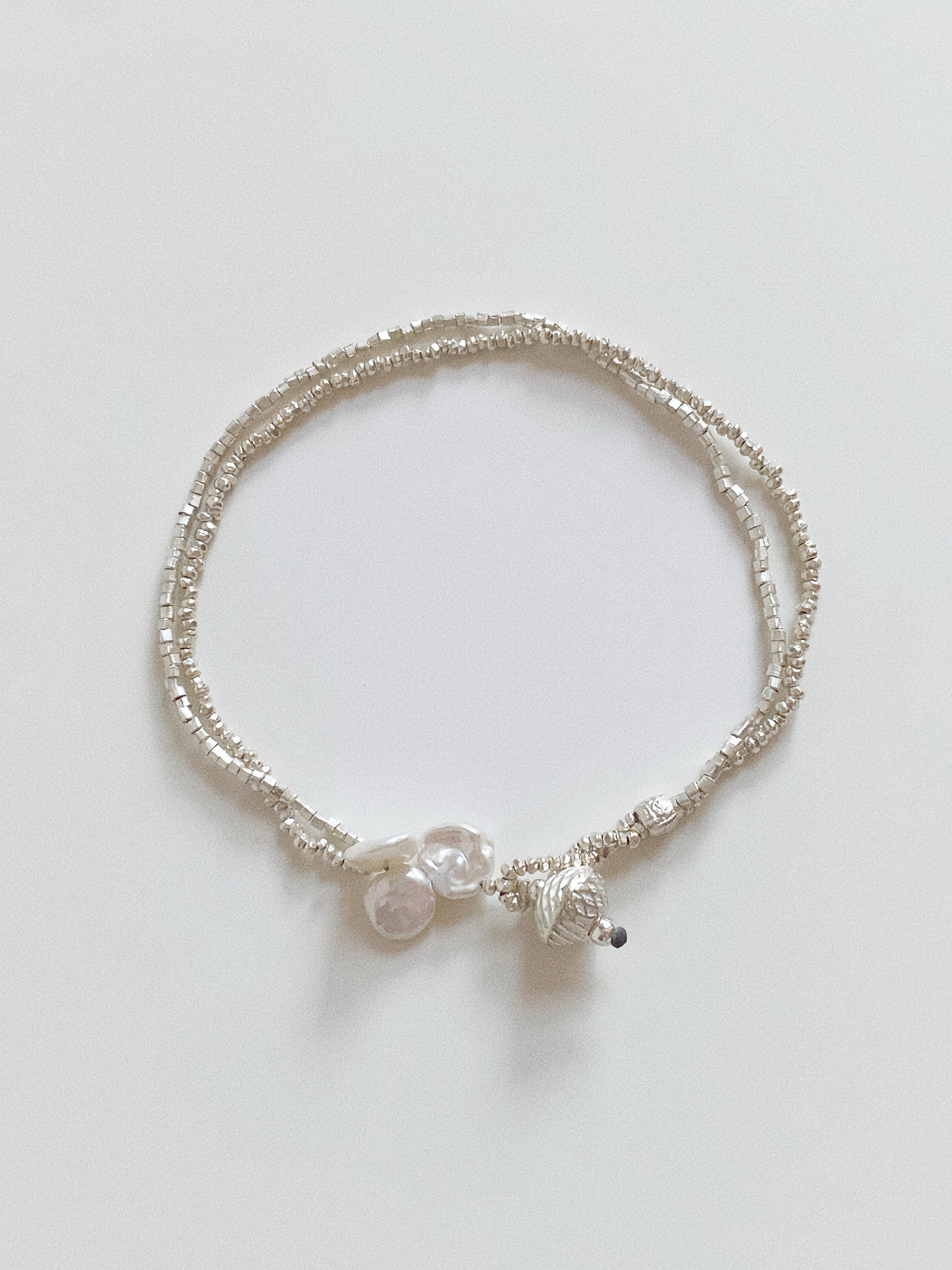 Double layer handmade 925 sterling silver bracelet featuring faceted beads and organic pearl details.