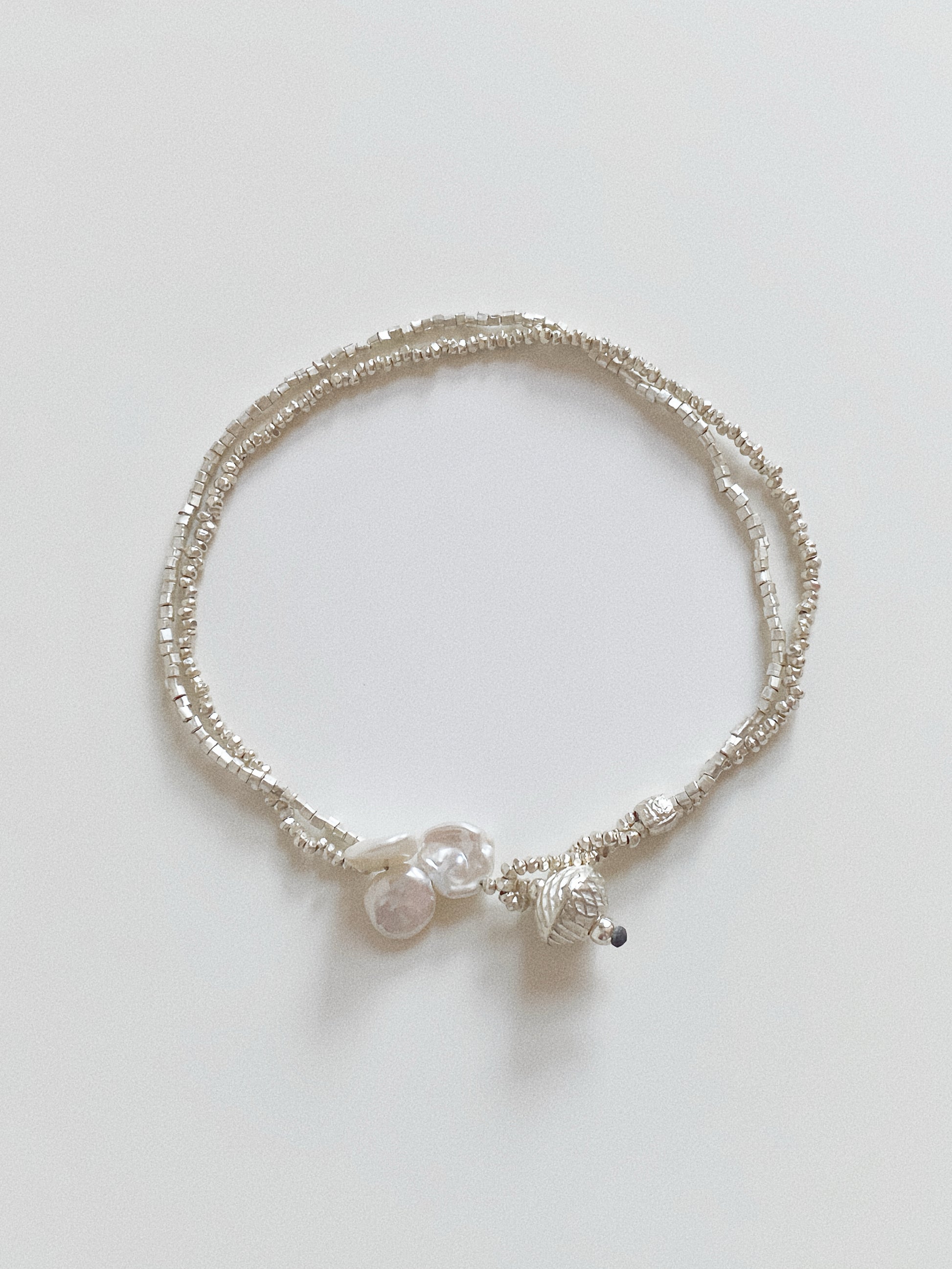Double layer handmade 925 sterling silver bracelet featuring faceted beads and organic pearl details.