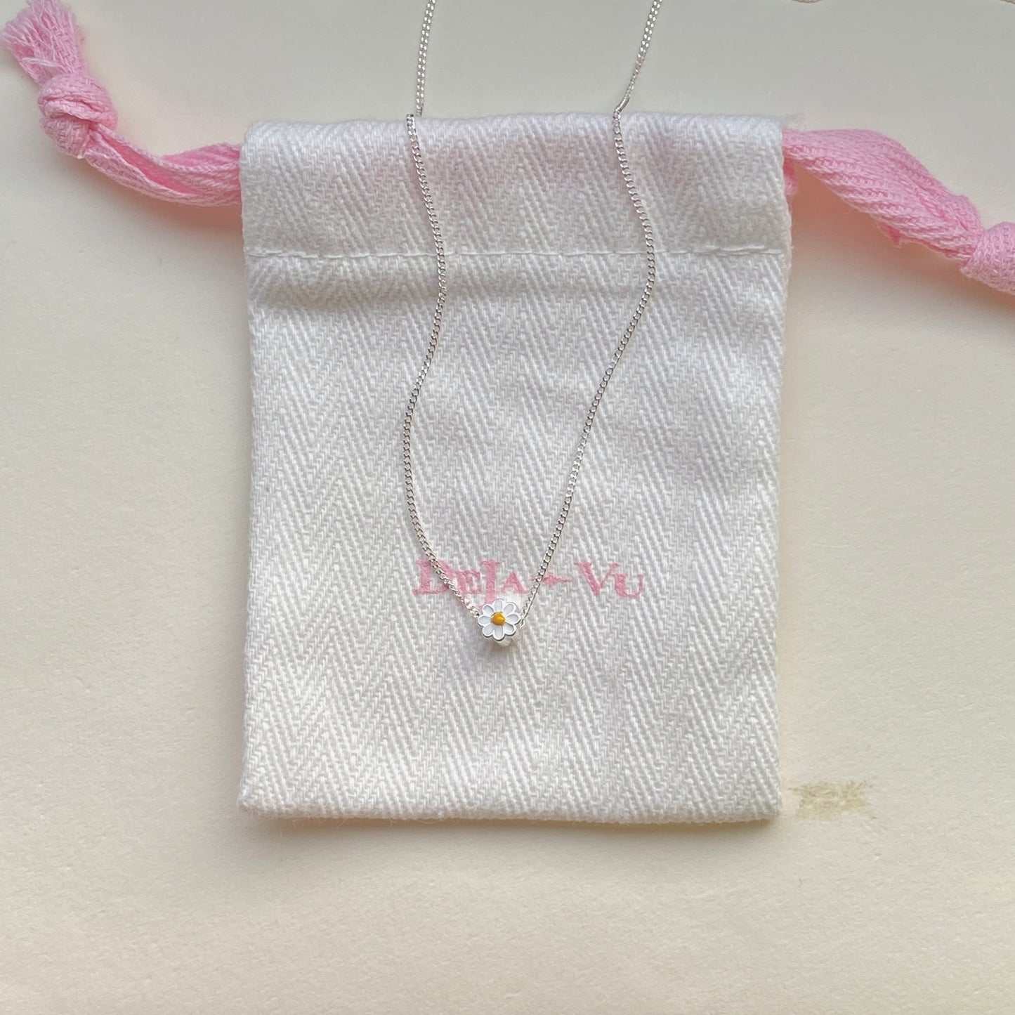 Sterling-silver daisy pendant necklace laid flat, 40–45 cm adjustable