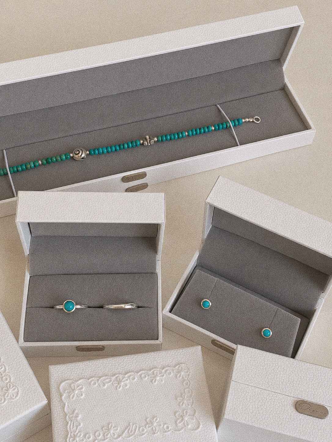 Cove turquoise ring displayed alongside coordinating turquoise and silver jewellery in Deja vu Jewellery gift boxes.