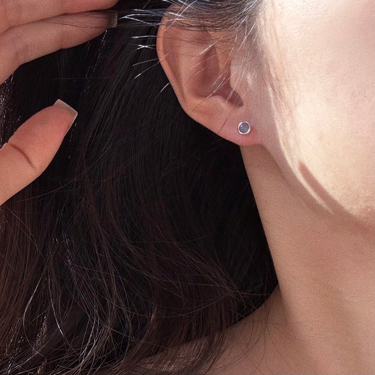 Close up of the 5-6mm Tanzanite stud on the earlobe, demonstrating the perfect size for a second hole or helix piercing.