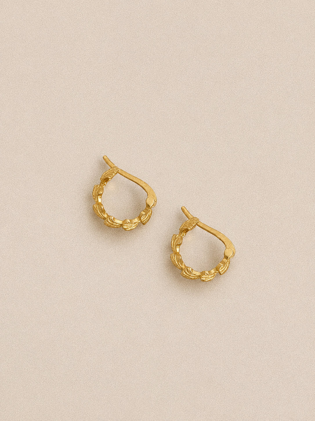 Rear view of the Grove gold leaf huggie hoops showing the thick gold-plated finish and hinged fastening.