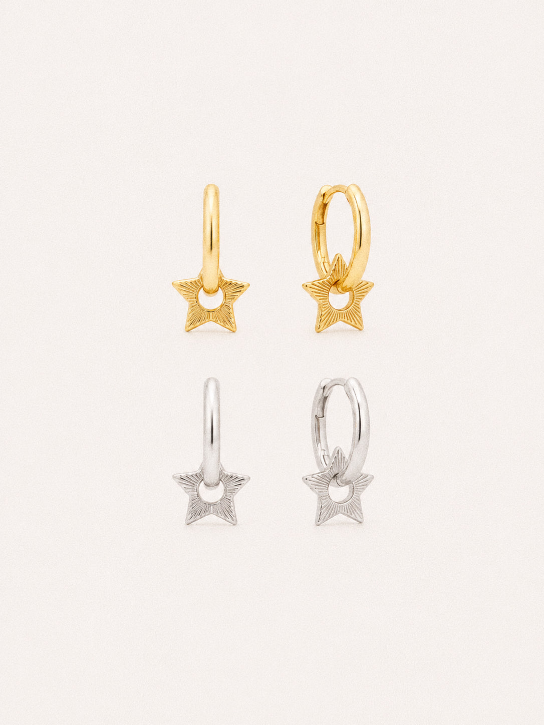 Nova star huggie hoop earrings in 18k gold plated and sterling silver, engraved sunburst star charms on small hoops.