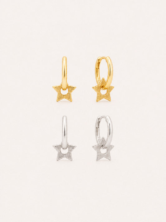 Nova star huggie hoop earrings in 18k gold plated and sterling silver, engraved sunburst star charms on small hoops.
