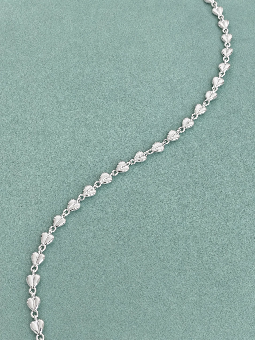 Close-up of a sterling silver heart link chain showing the rounded three-dimensional love heart links