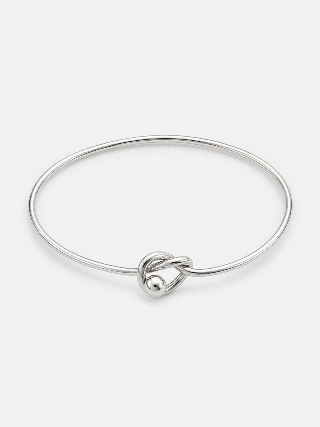 Front view of a fine sterling silver knot bangle showing the open cuff band and central love knot