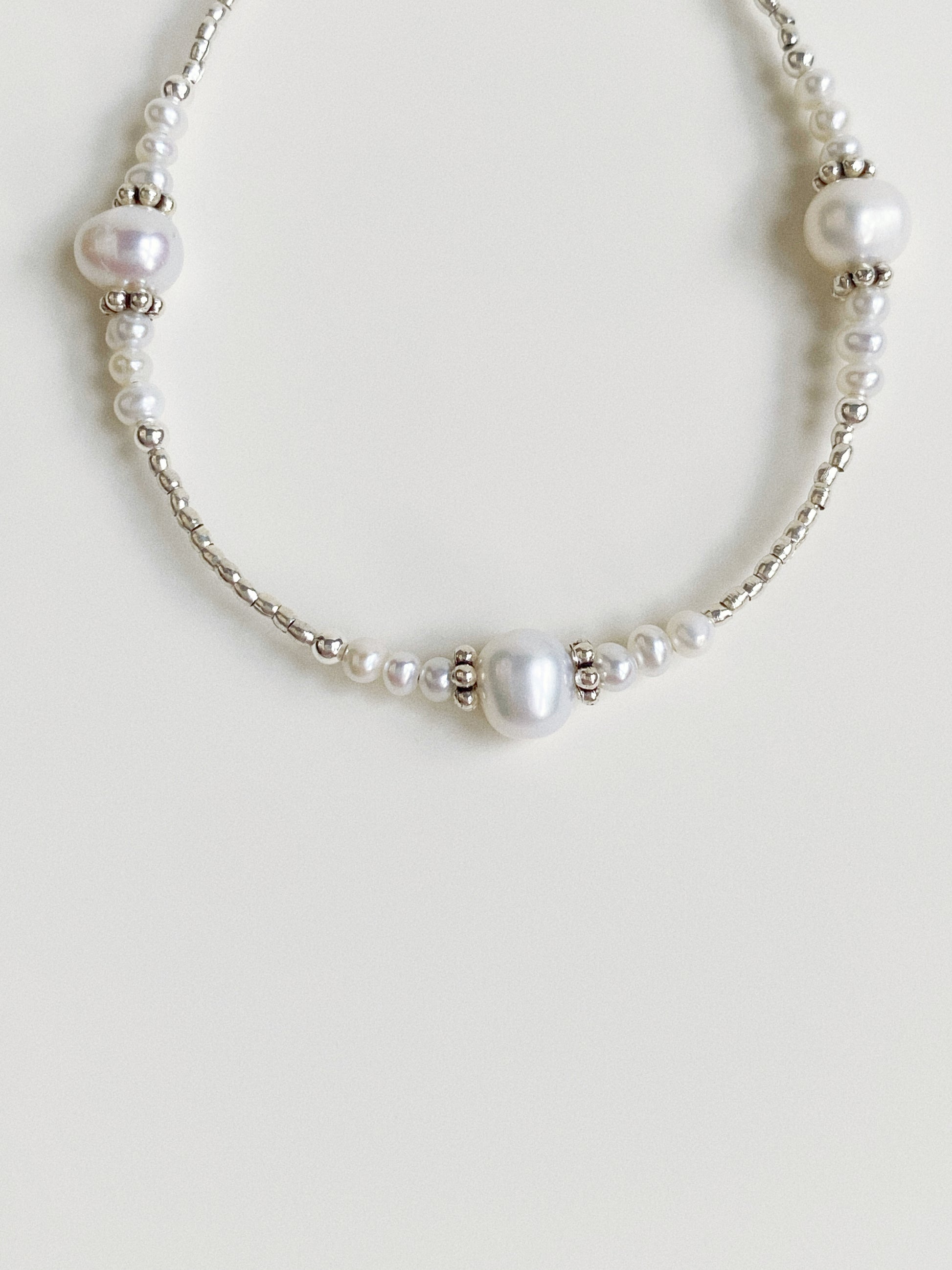 Detailed view of the 925 sterling silver clasp and extension chain on a pearl beaded bracelet.