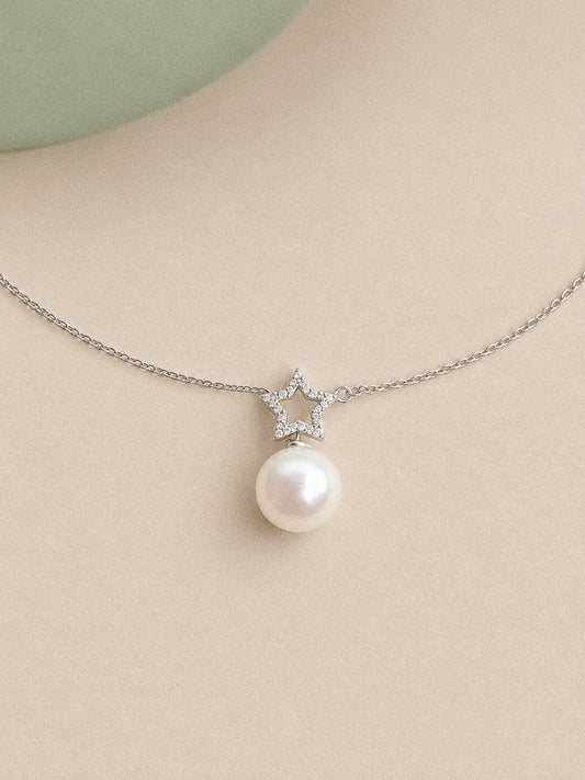 Close view of the sterling silver open star, clear accent stones and high-lustre round Edison pearl.