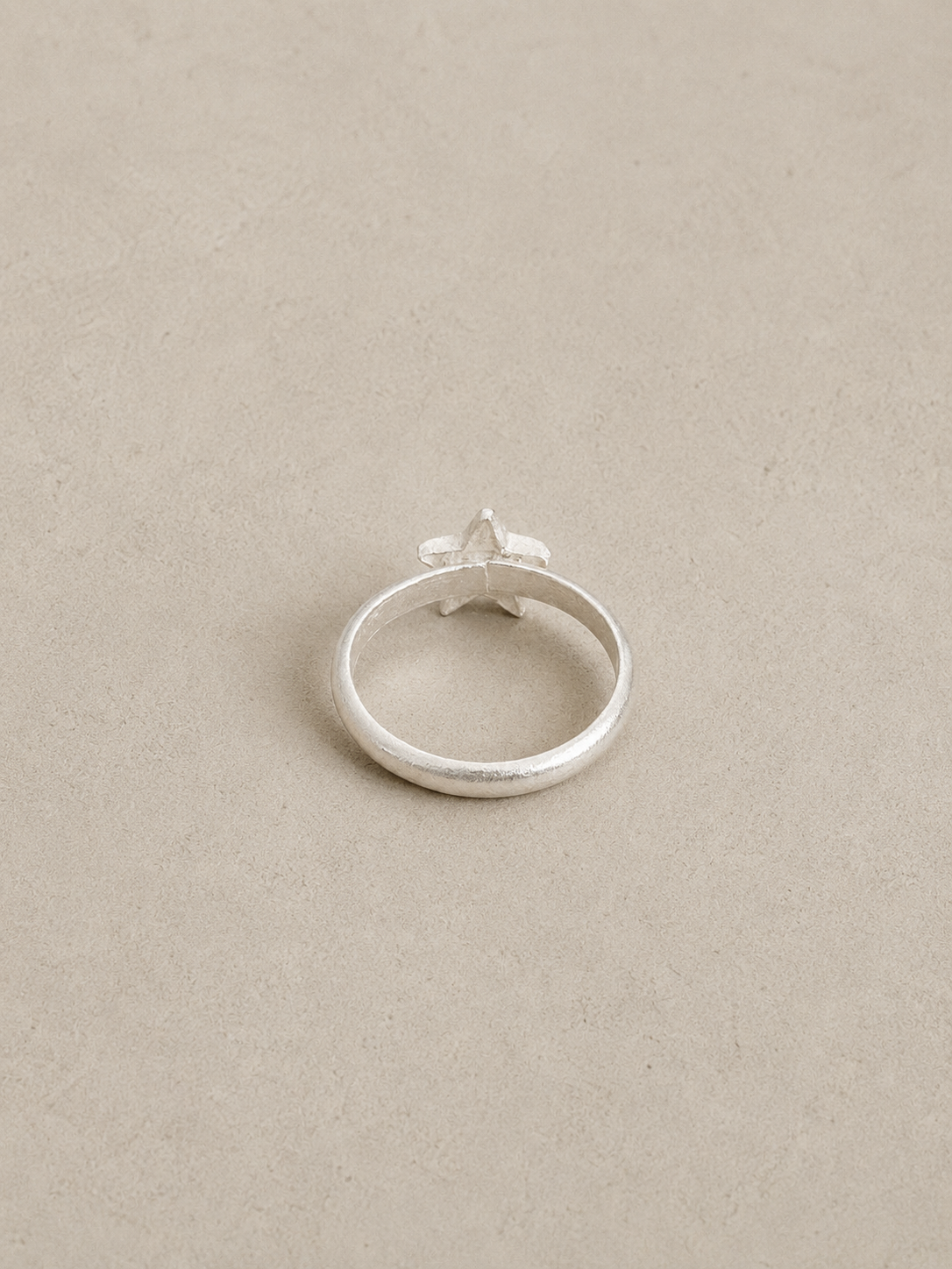Back view of the silver star ring showing its smooth rounded sterling silver band.
