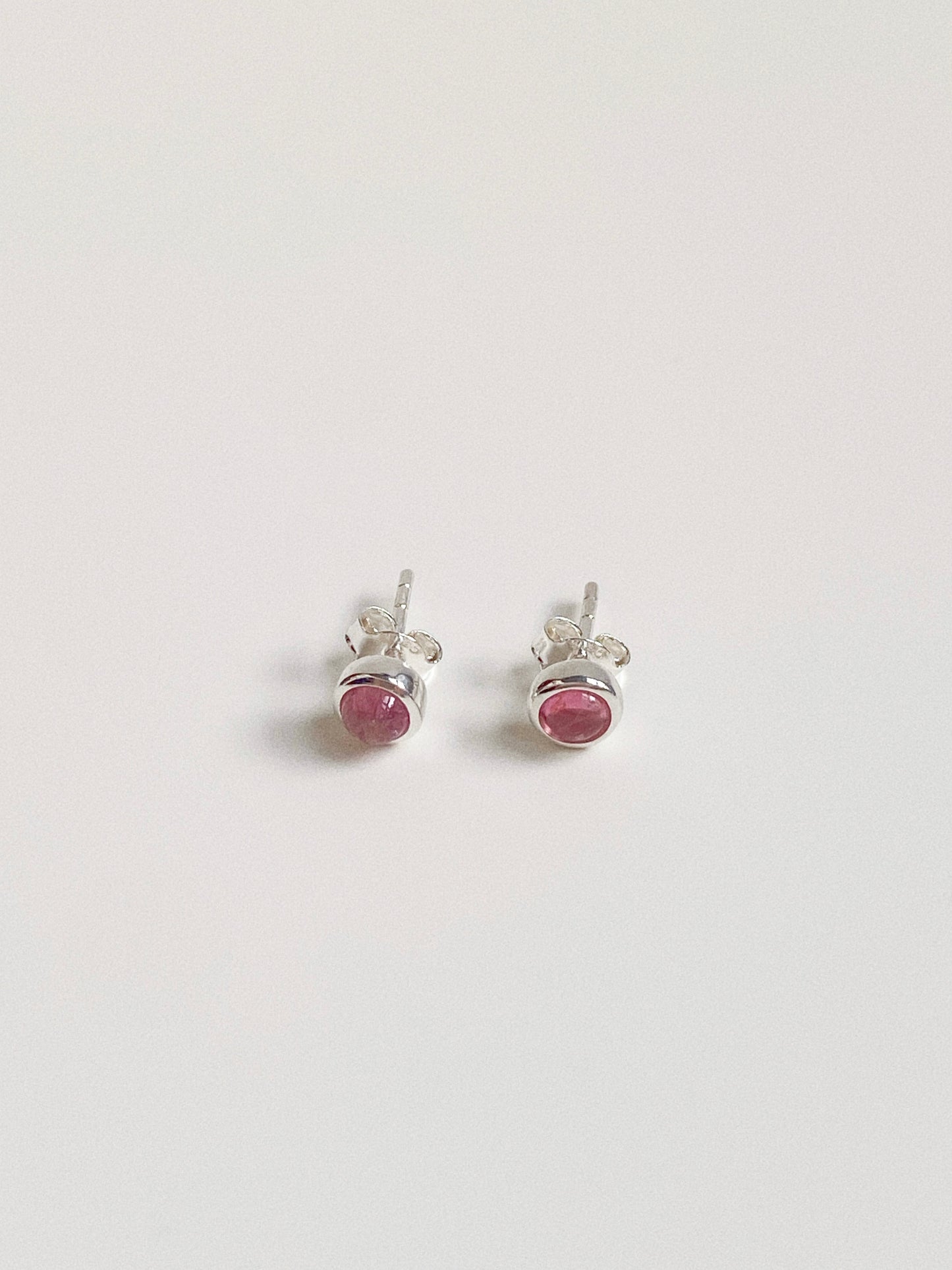 Close up detail of the natural pink gemstone studs, highlighting the organic texture and silver posts.