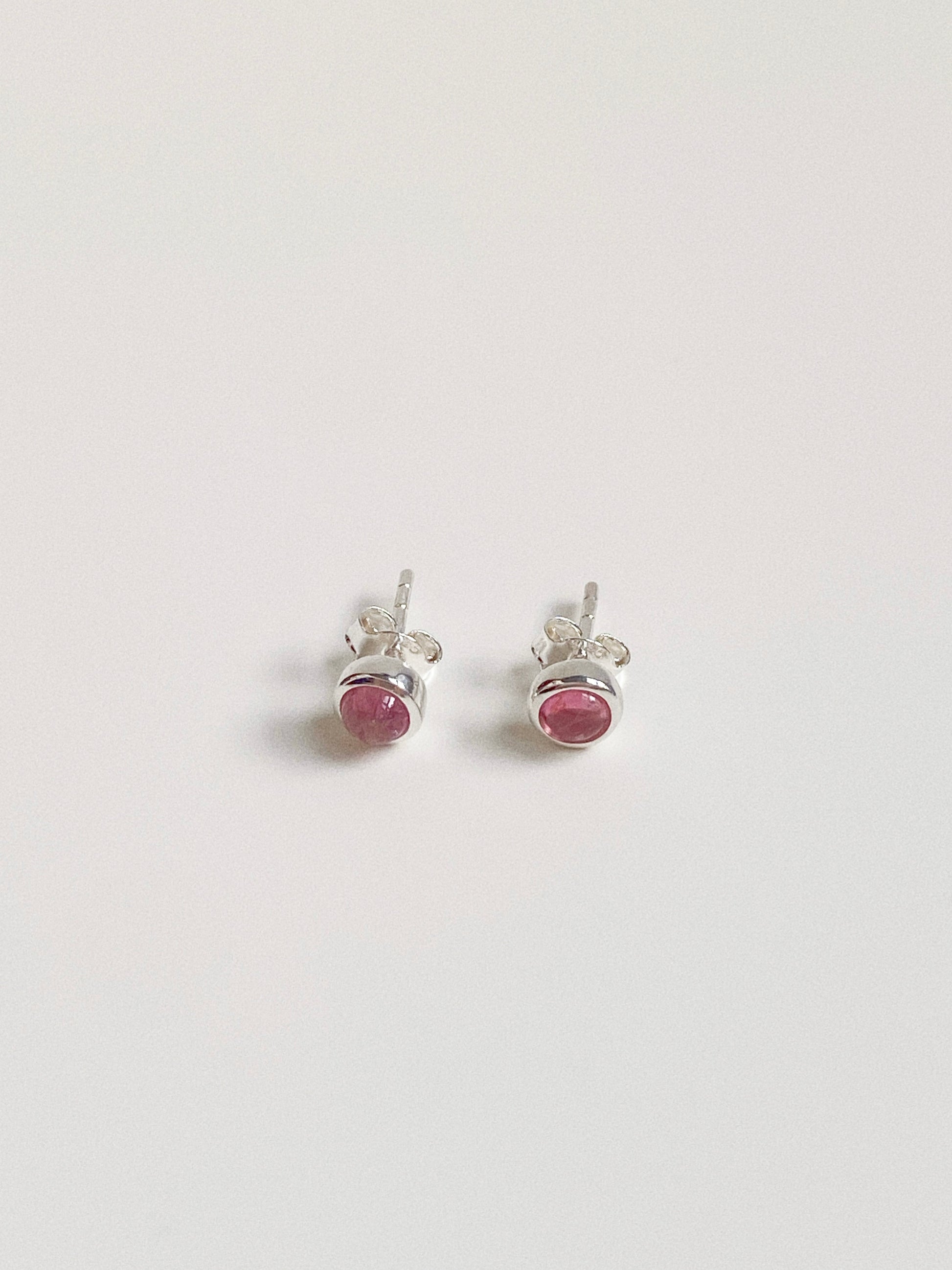 Close up detail of the natural pink gemstone studs, highlighting the organic texture and silver posts.