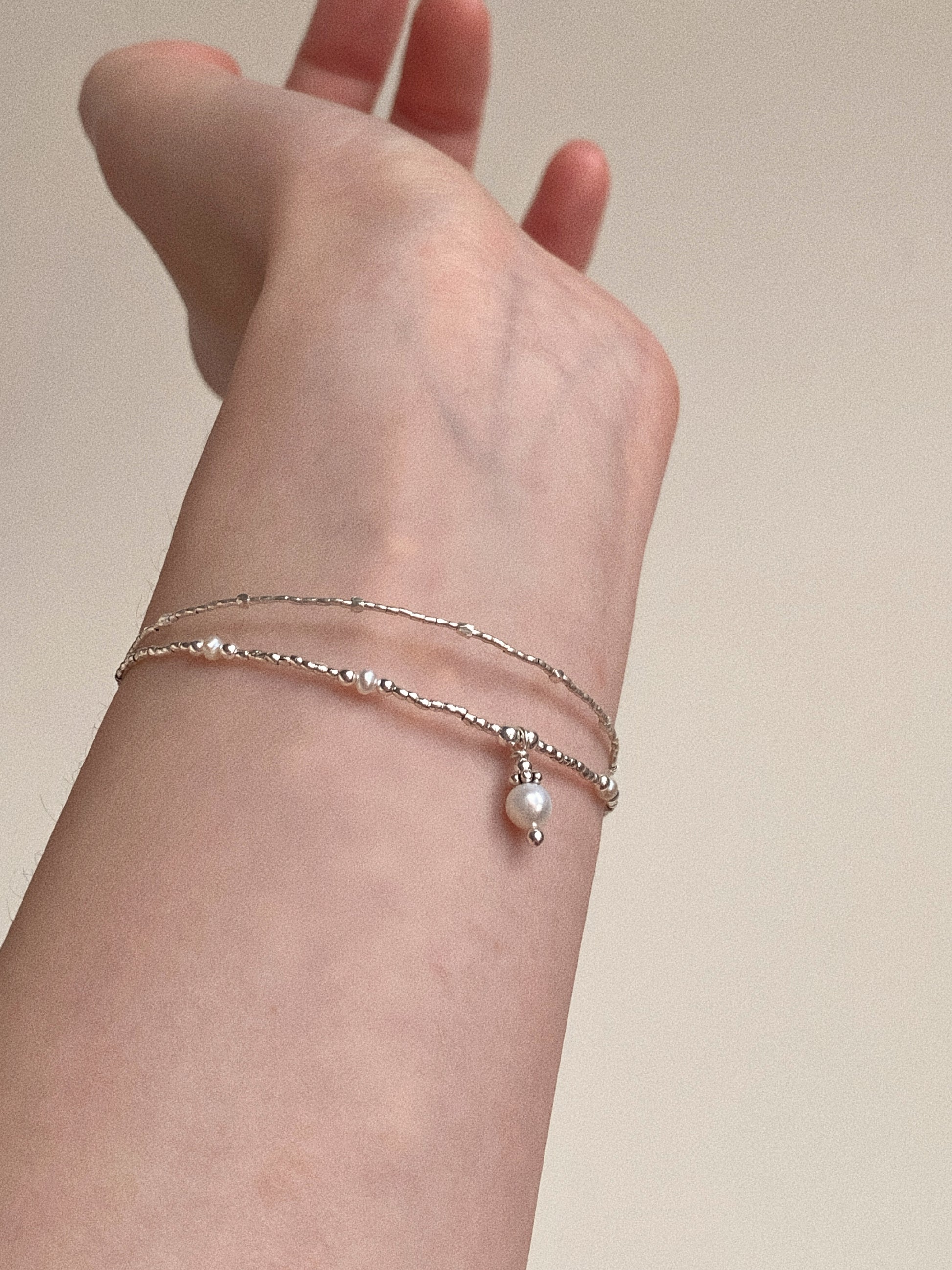 Side view of the pearl and silver fashion bracelet, highlighting the elegant contrast of materials.