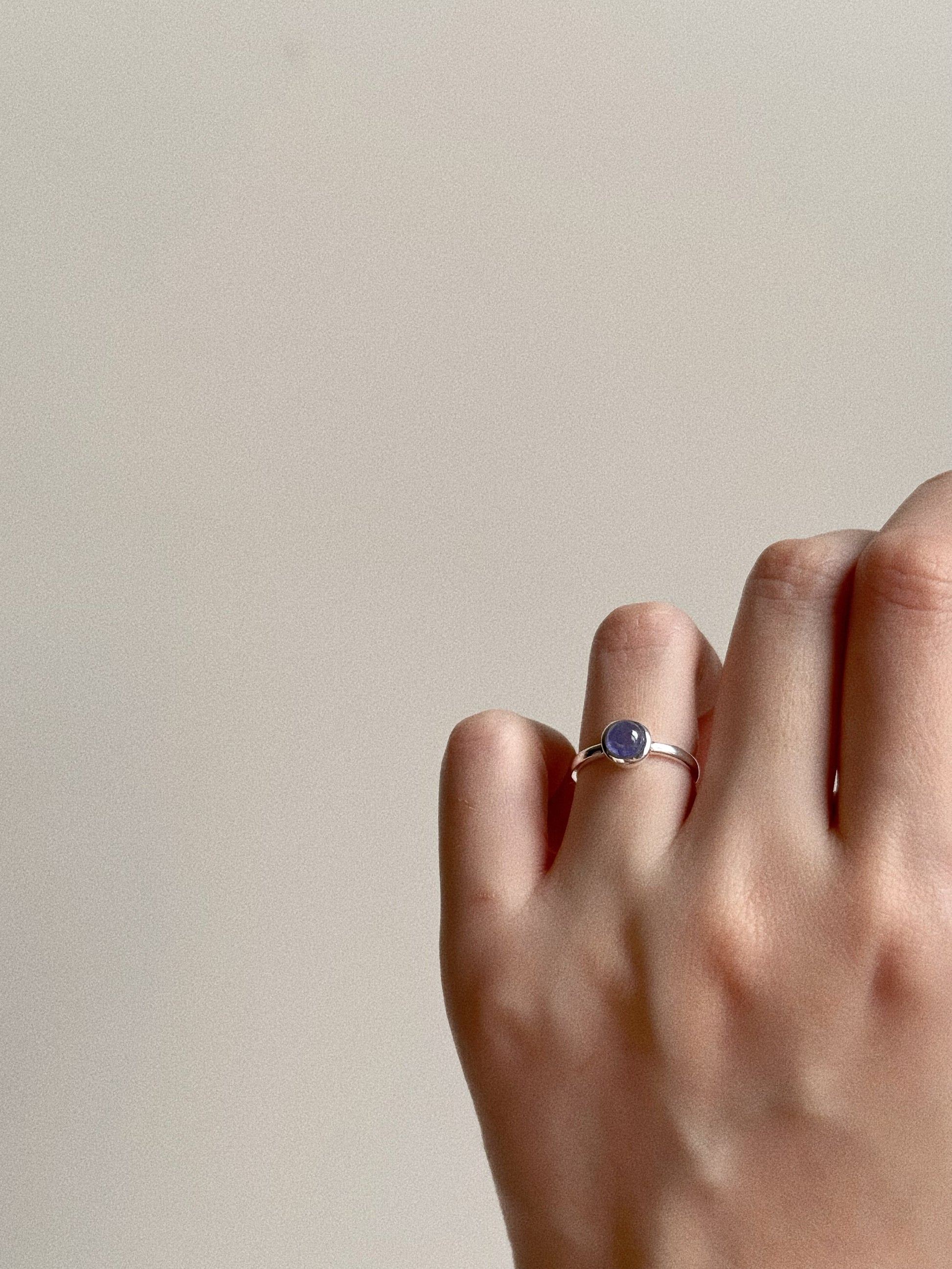 Model wearing the Natural Tanzanite Bubble Ring on the ring finger, showcasing the vibrant blue color against skin.