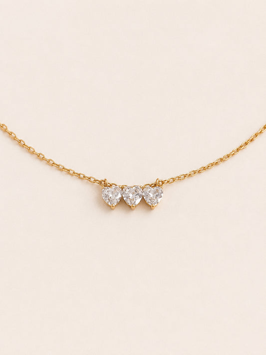 Trio three heart necklace with claw set cubic zirconia hearts in a row on a fine 18k gold chain