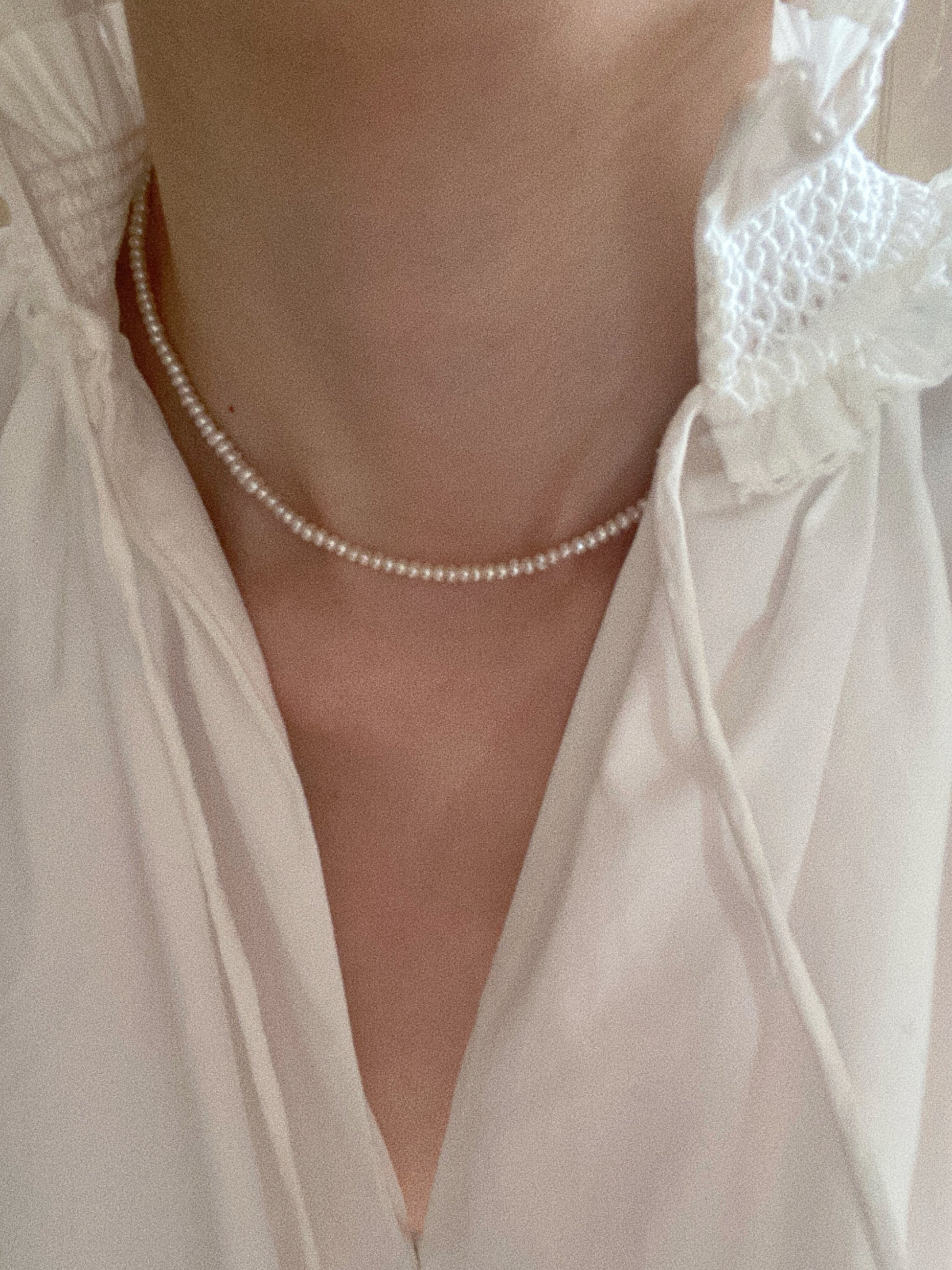 Dainty tiny pearl choker styled on model in white blouse for soft minimalist look
