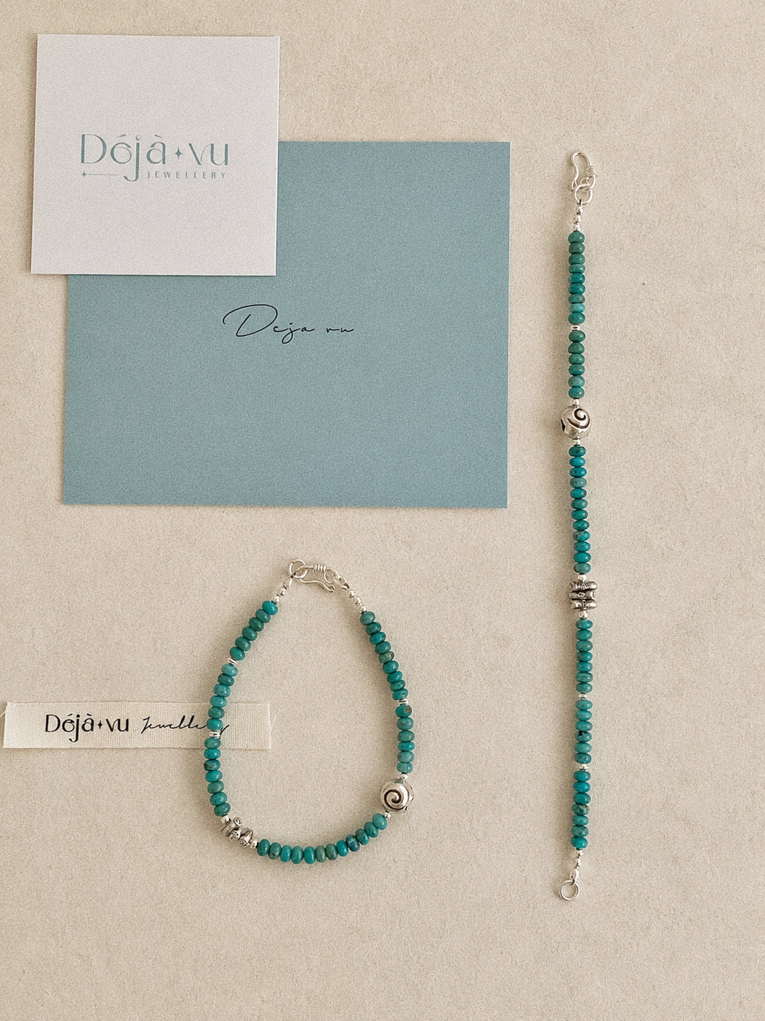 Two handmade turquoise bracelets laid flat with Deja Vu Jewellery cards showing the hook clasp detail