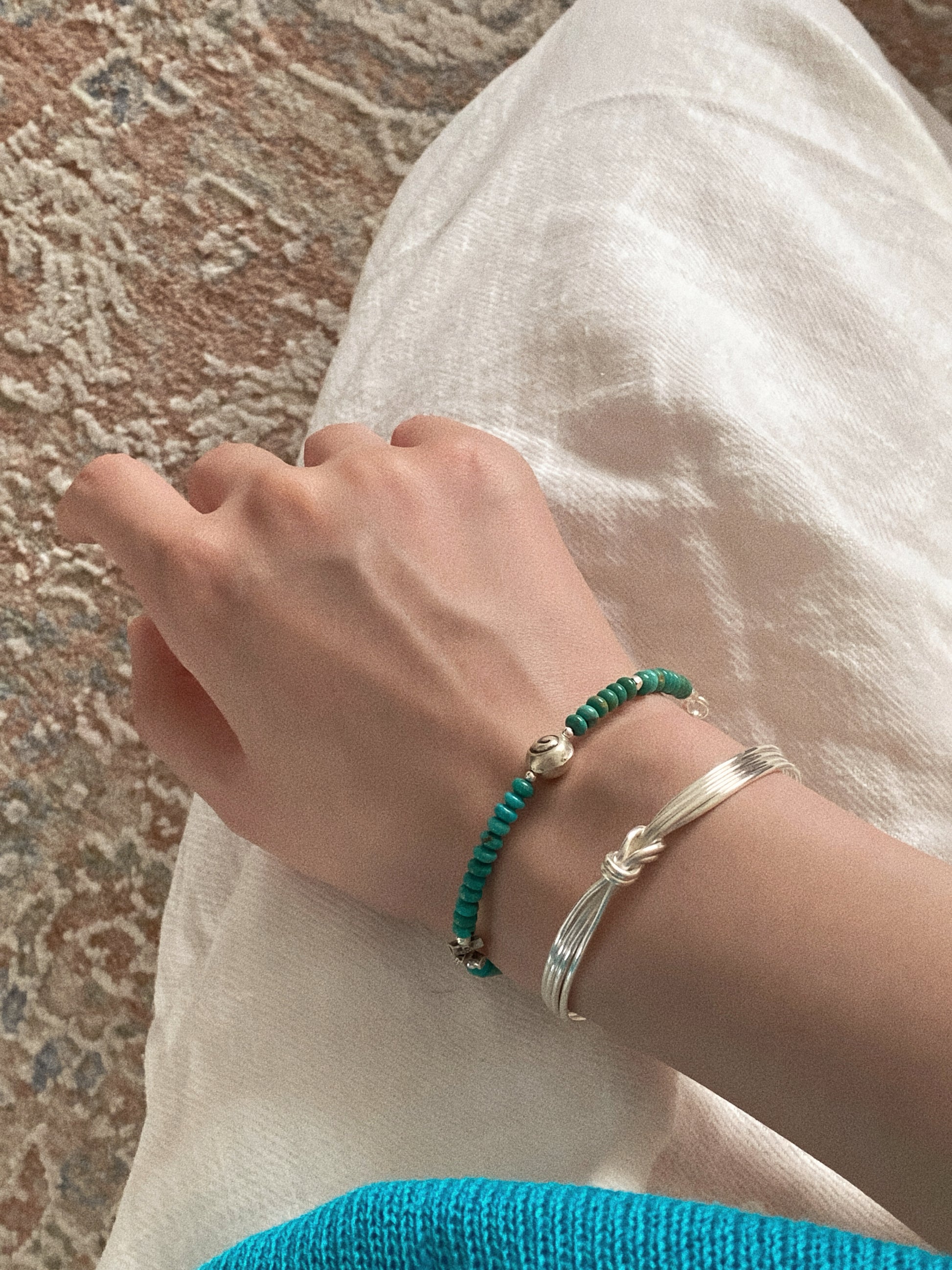 Kathmandu turquoise bracelet worn stacked with a hand tied silver knot bangle