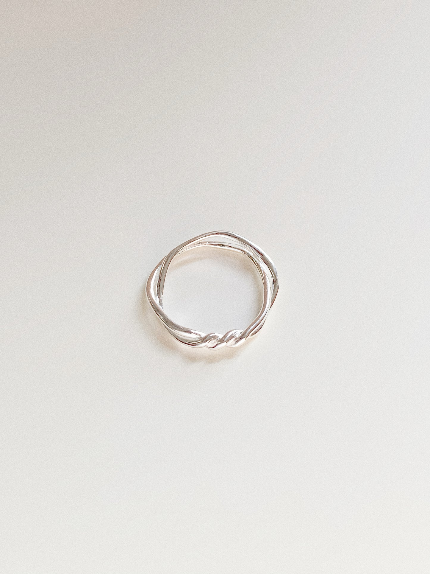 Top-down view of a double-layer 925 sterling silver ring with an intertwined twisted knot design on a white background.