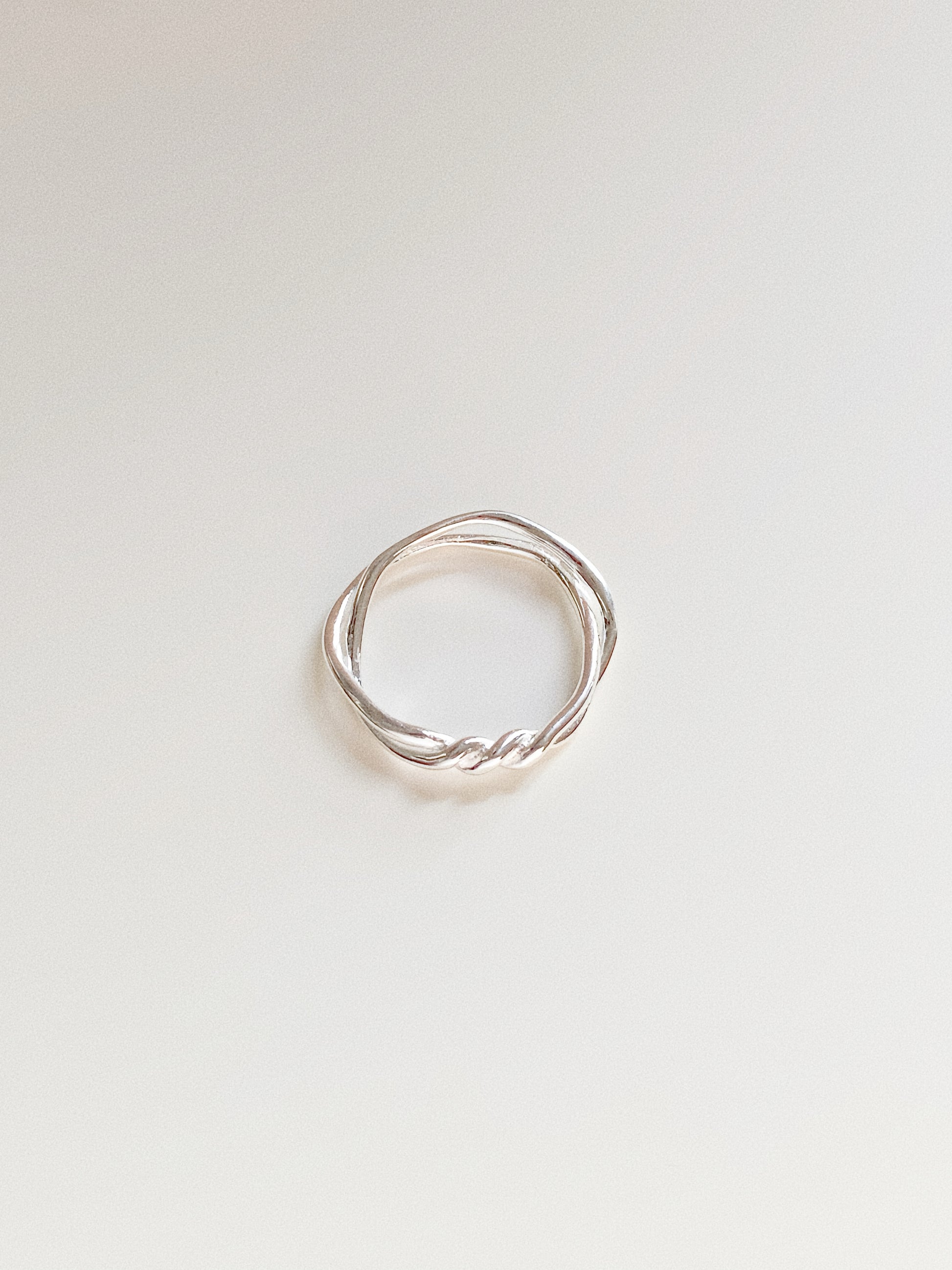 Top-down view of a double-layer 925 sterling silver ring with an intertwined twisted knot design on a white background.