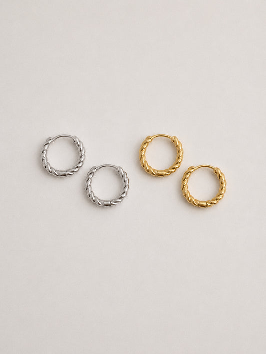 Silver and gold twisted rope huggie hoop earrings shown side by side, 925 sterling silver hoops in both finishes
