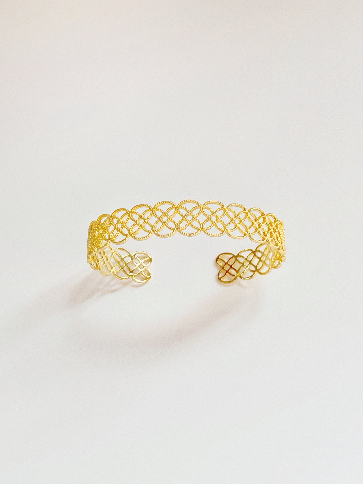 A close-up of the 9mm gold Arabesque Petal Lace Cuff showing the intricate filigree cut-out pattern.