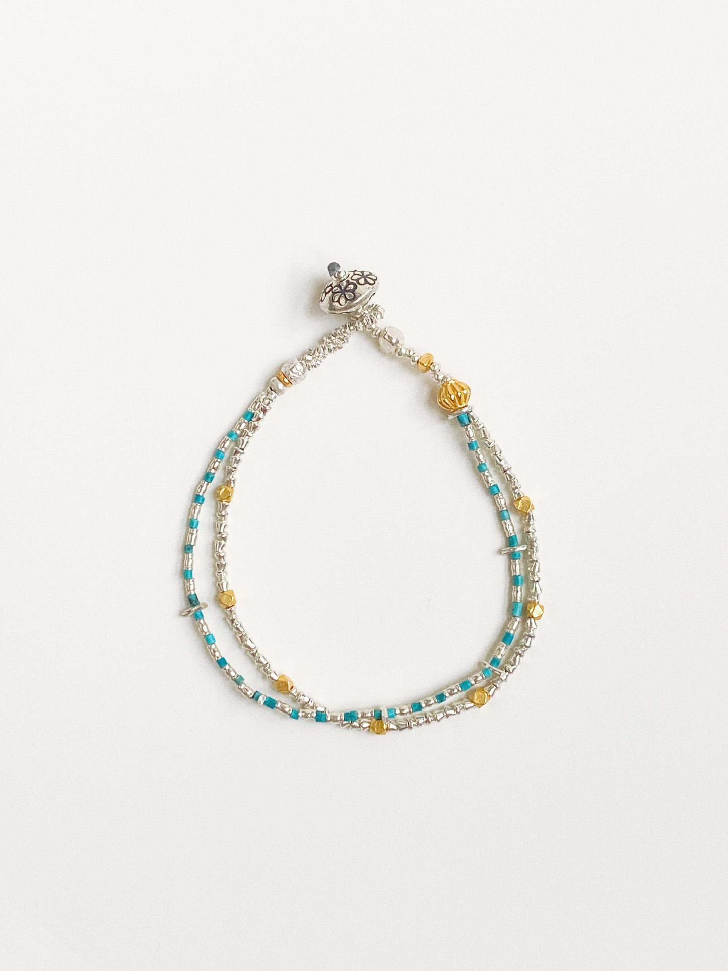 Handmade double-layer turquoise bracelet with Thai silver and 24k gold-plated beads flat lay by Deja Vu Jewellery