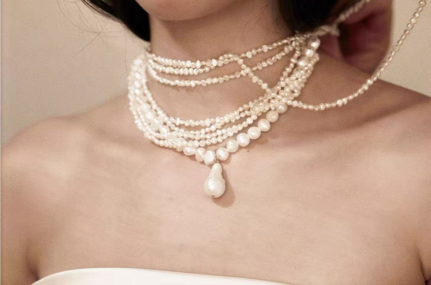 Close up of 5-strand pearl choker on neck, showing the mix of seed pearls and large baroque pearls fitting at 40cm length.