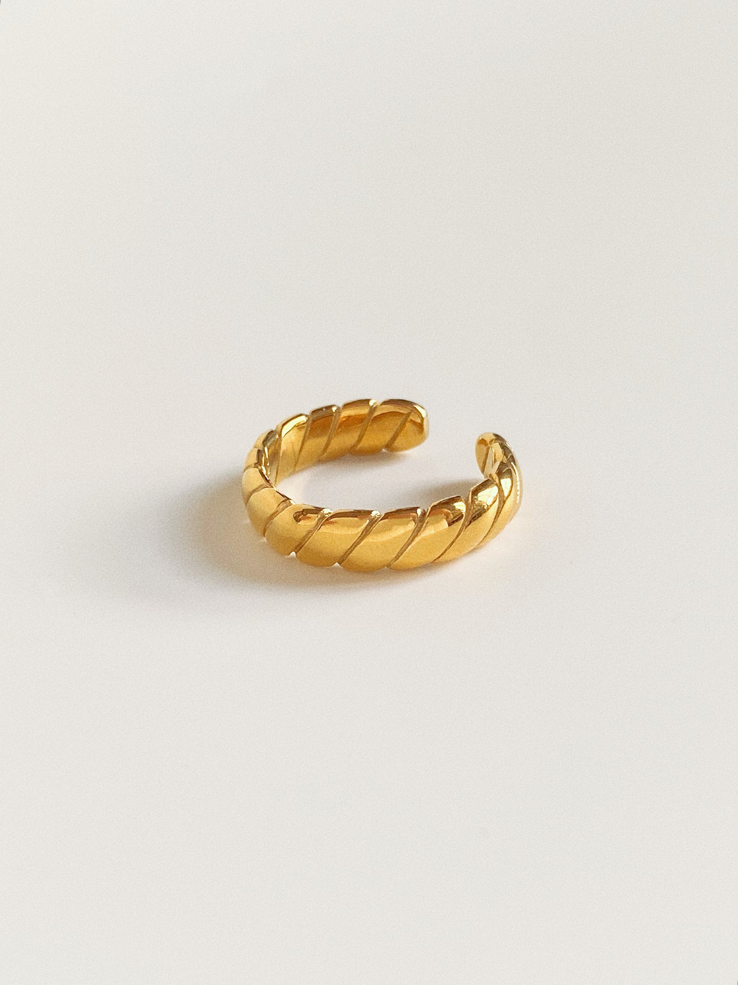 Close-up detail of a wide gold slanted stripe dome ring showing the high-polish finish.