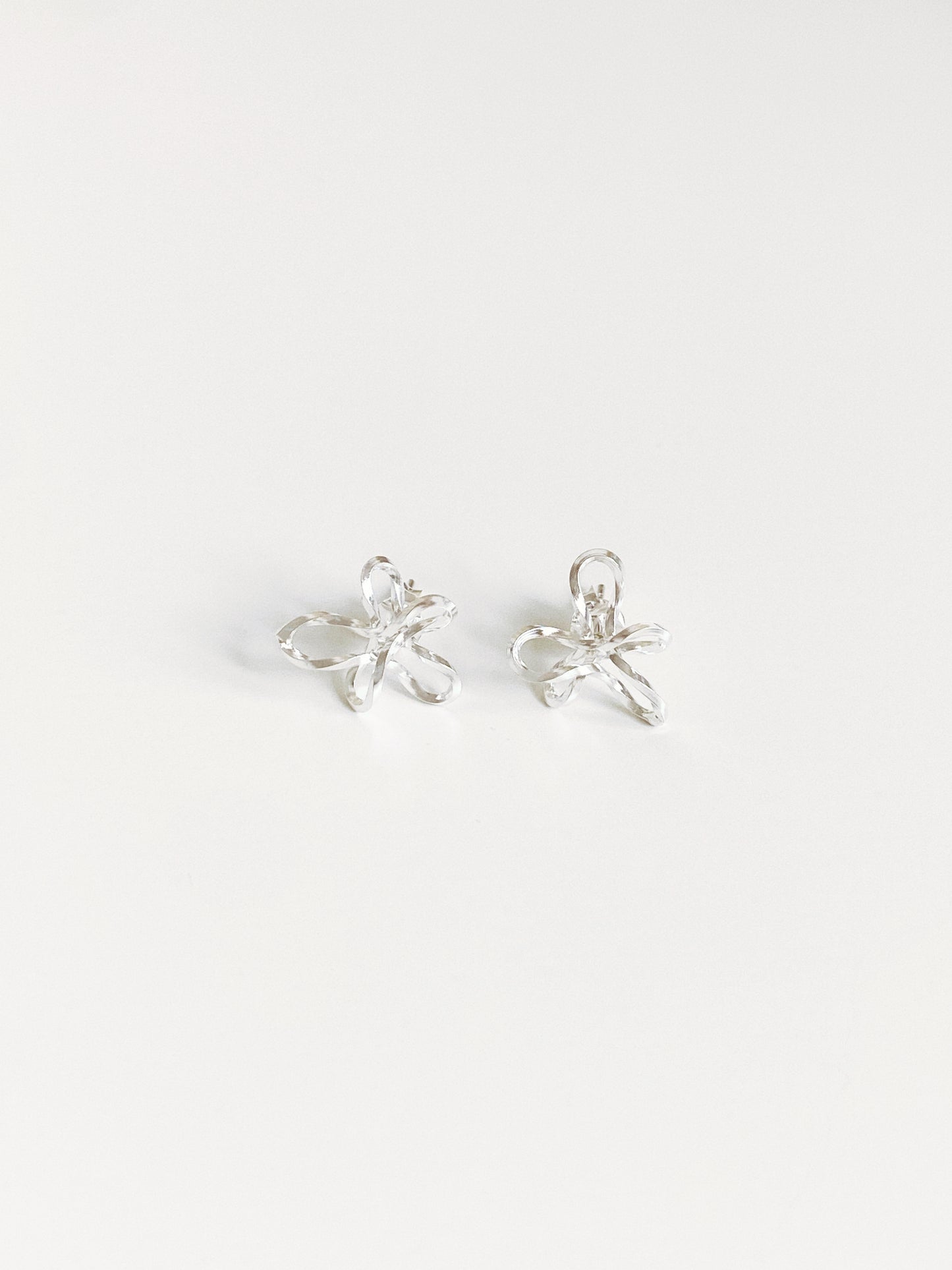Sculptural wire flower stud earrings in 925 sterling silver flat lay by Deja Vu Jewellery