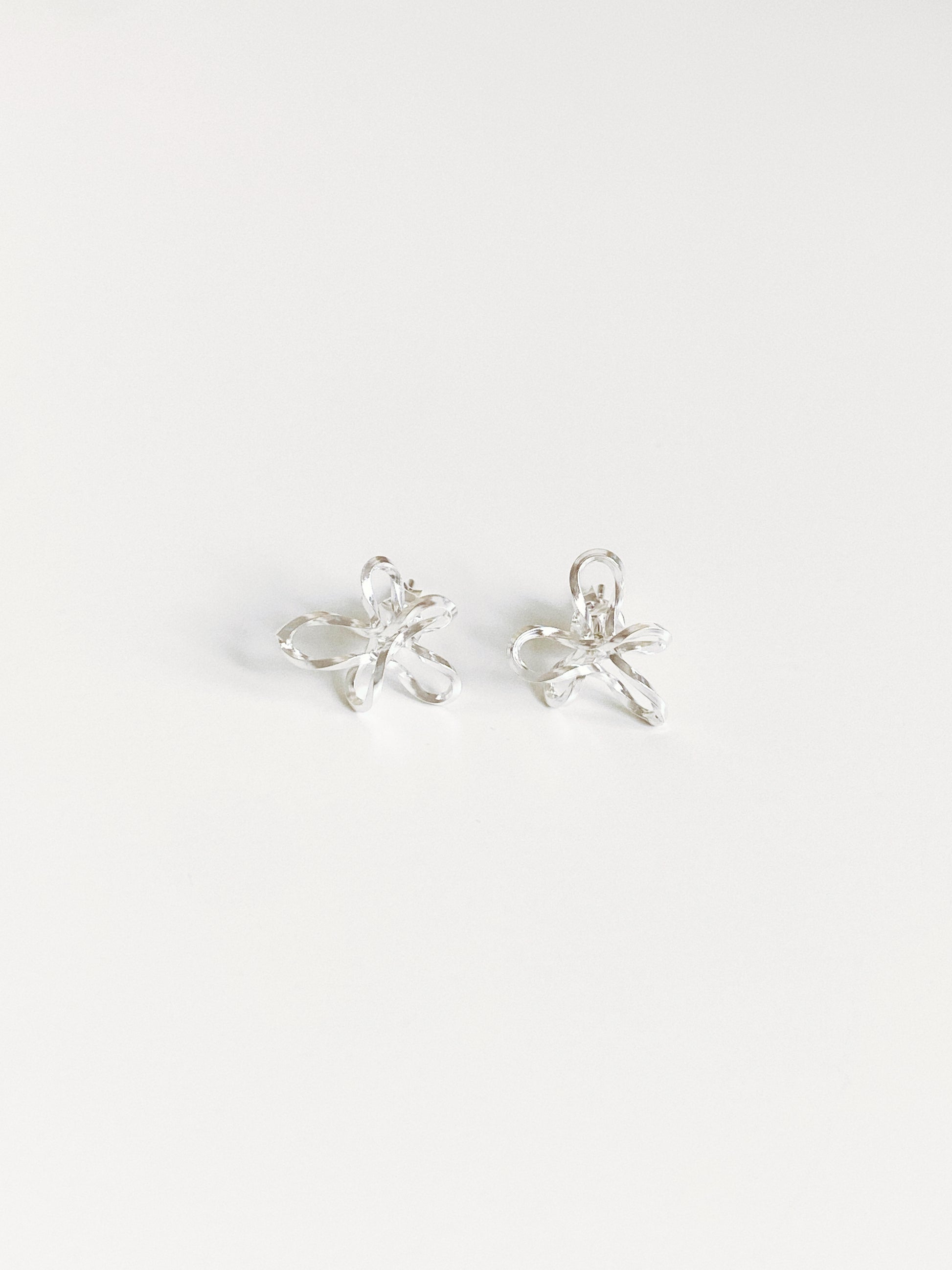 Sculptural wire flower stud earrings in 925 sterling silver flat lay by Deja Vu Jewellery